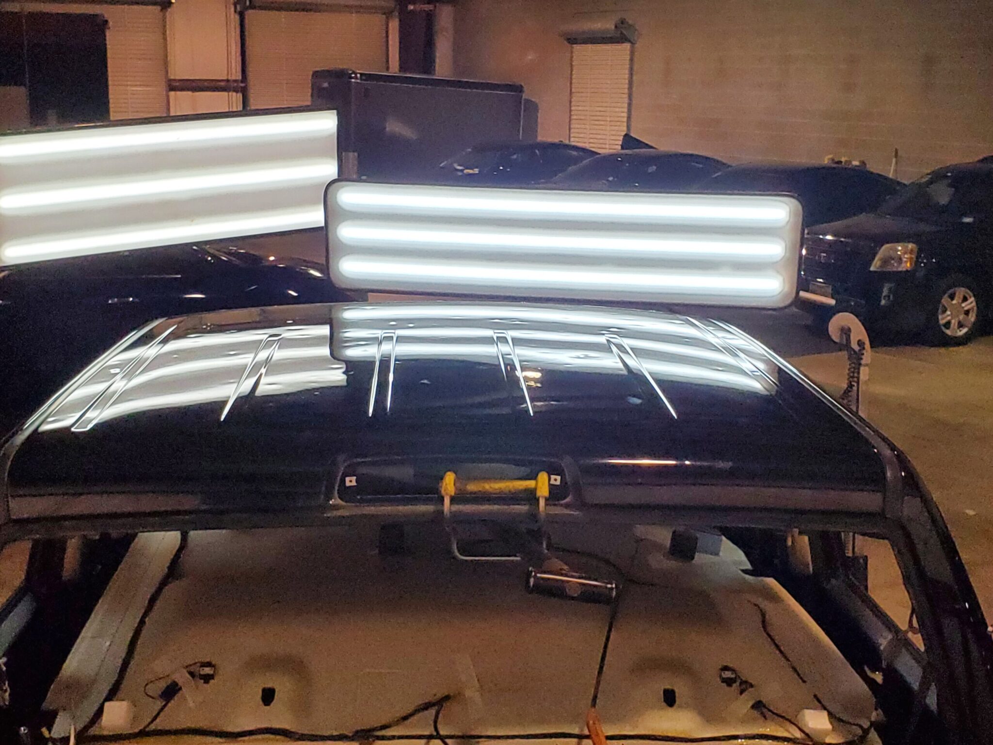 Hail damage inspection under shop lights at Trident Killeen