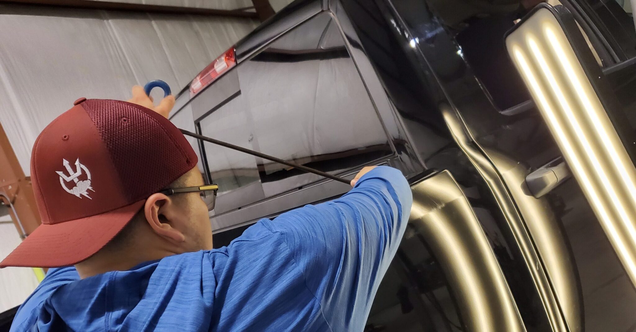 Technician working a hail dent at the Killeen shop